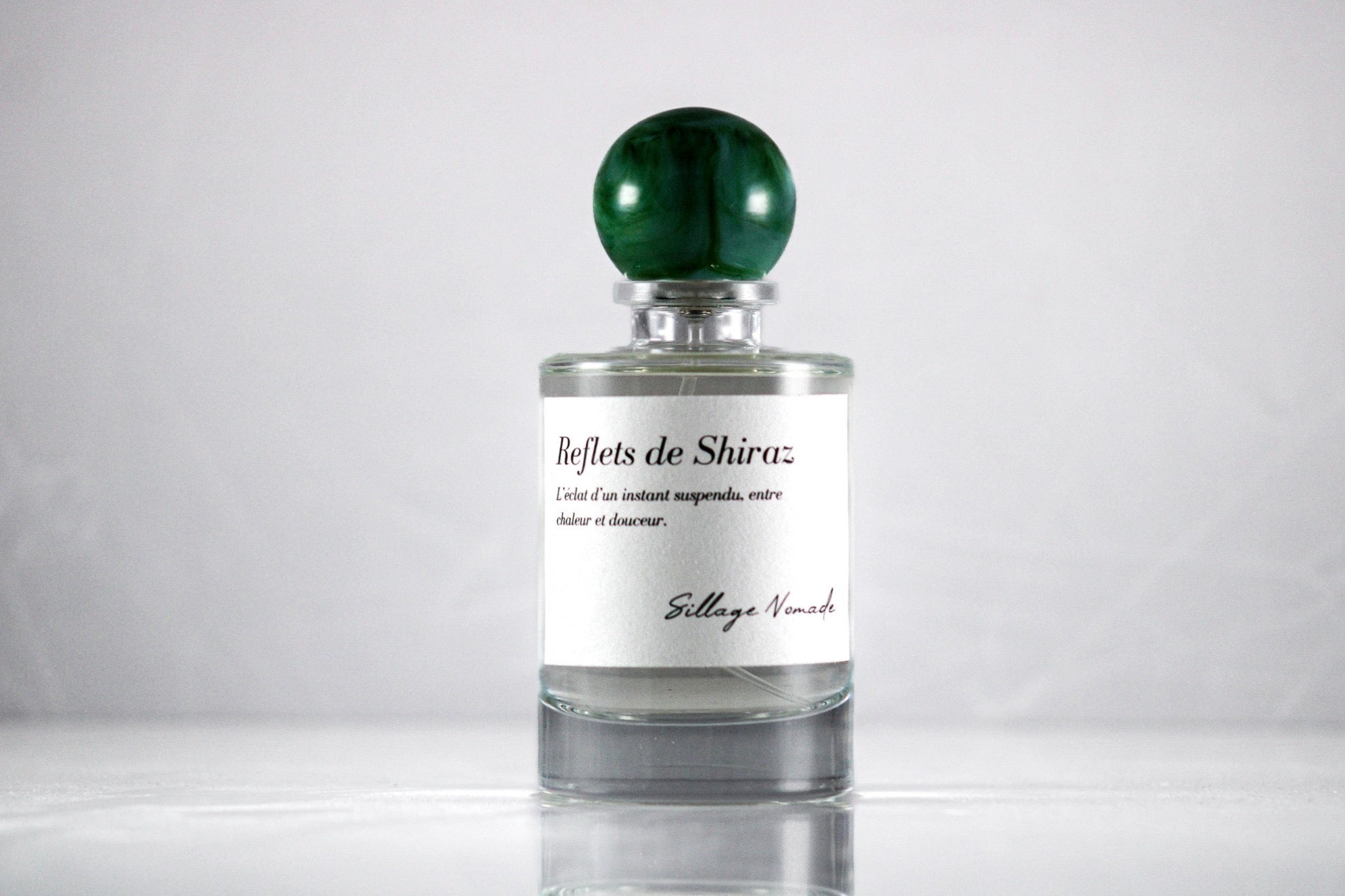 Flacon de parfum Reflets de Shiraz Sillage Nomade avec étiquette élégante et design sophistiqué.